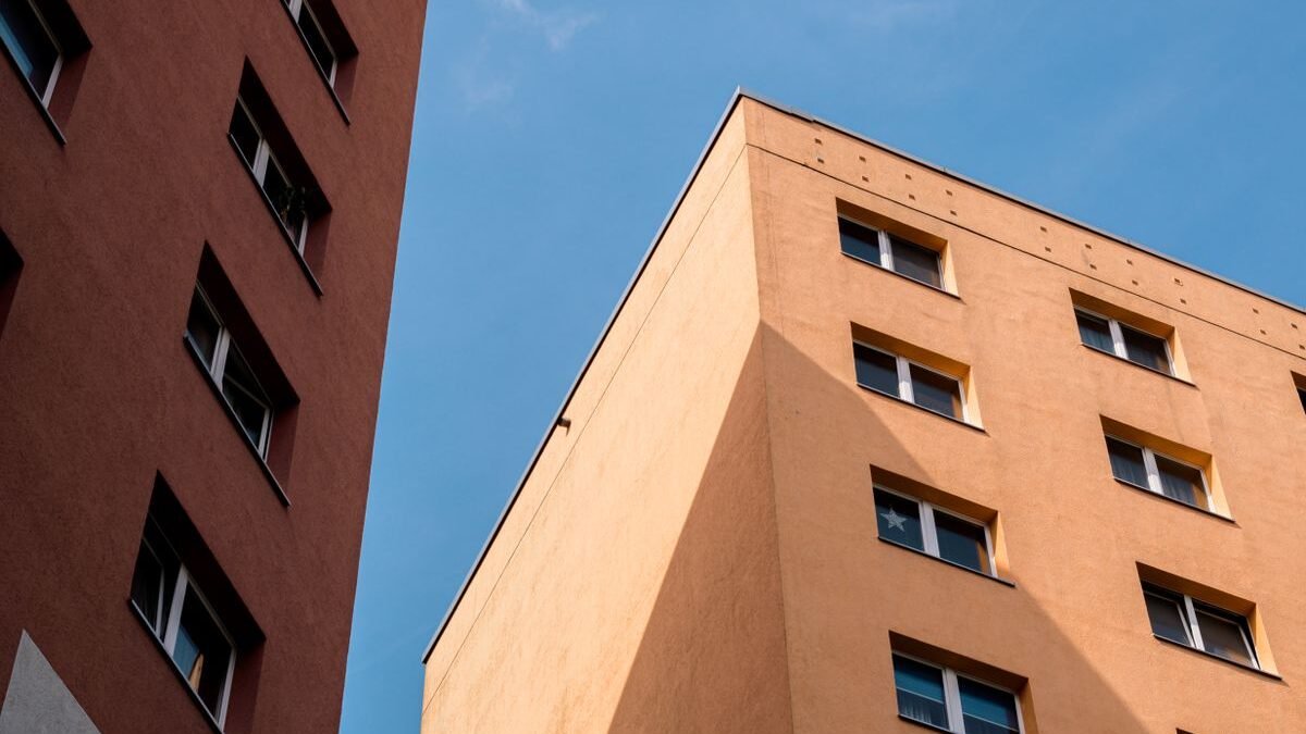 Capture of plattenbau style apartment buildings under clear blue sky