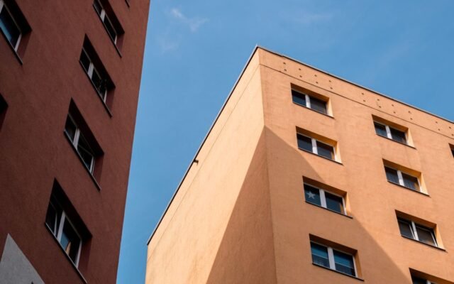 Capture of plattenbau style apartment buildings under clear blue sky