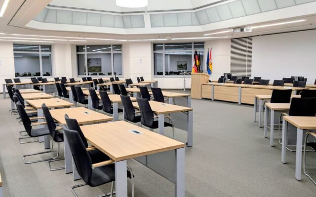 Spacious and modern meeting room in with desks and flags