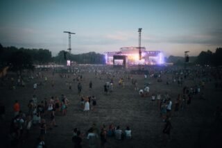 Vibrant outdoor concert scene with a lively crowd during dusk