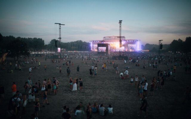 Vibrant outdoor concert scene with a lively crowd during dusk