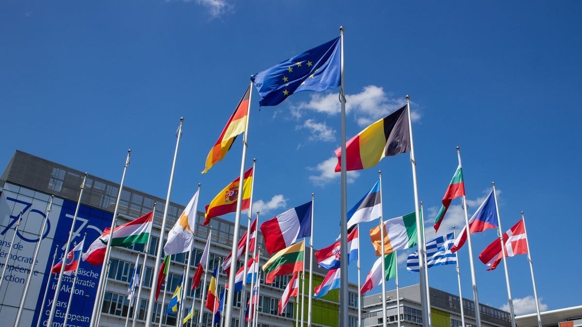 angle view of European Union flags on flagpoles against a blue sky