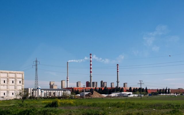 A large industrial facility with smokestacks and clear skies