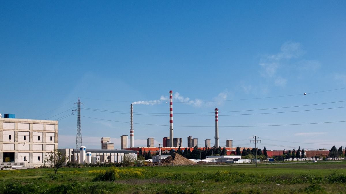 A large industrial facility with smokestacks and clear skies