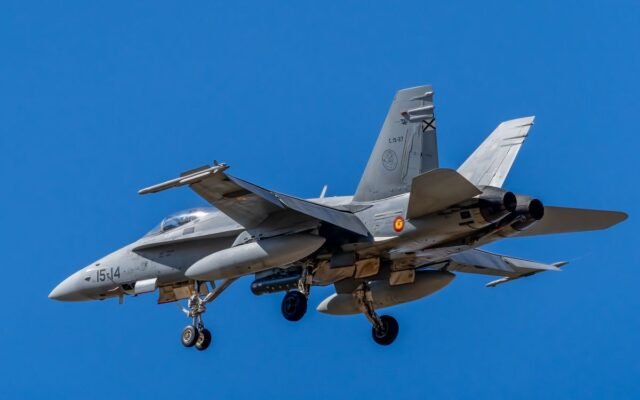 Close-up of a Spanish Air Force F/A-18 Hornet flying against a clear blue sky