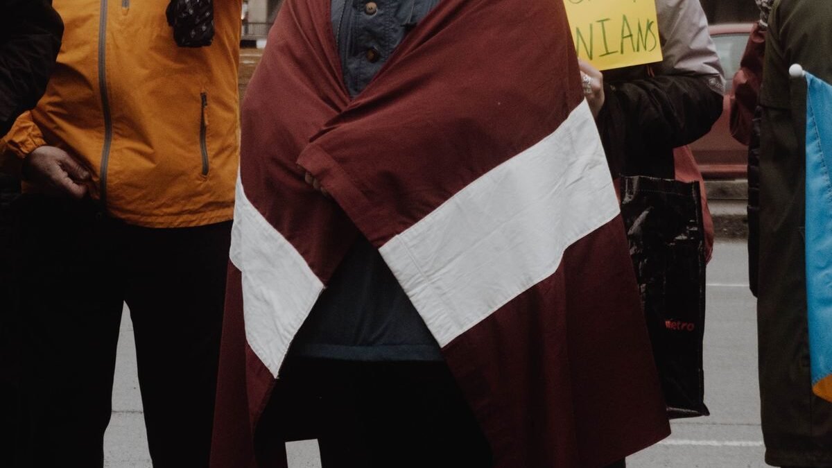 people holding a Latvian flag