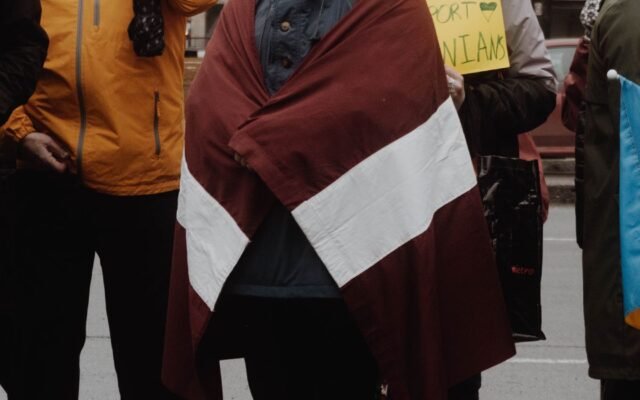 people holding a Latvian flag