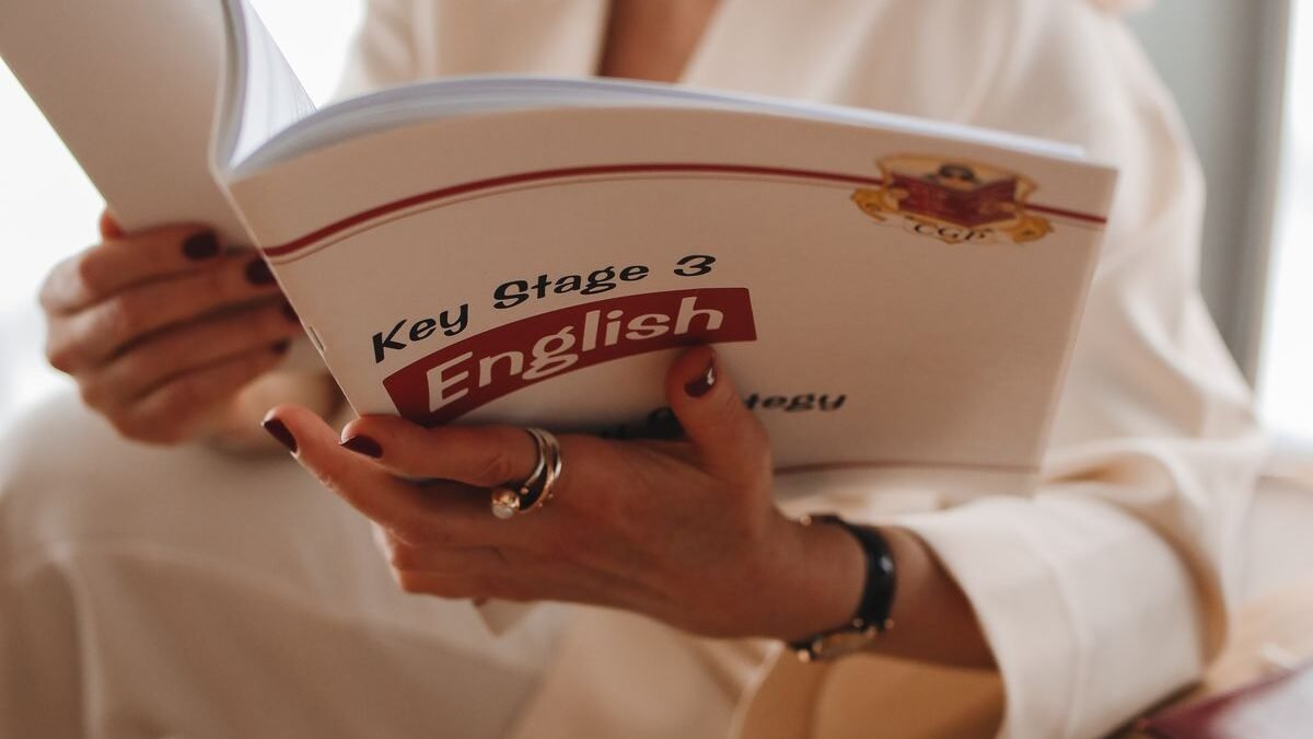 Adult woman reading a Key Stage 3 English book