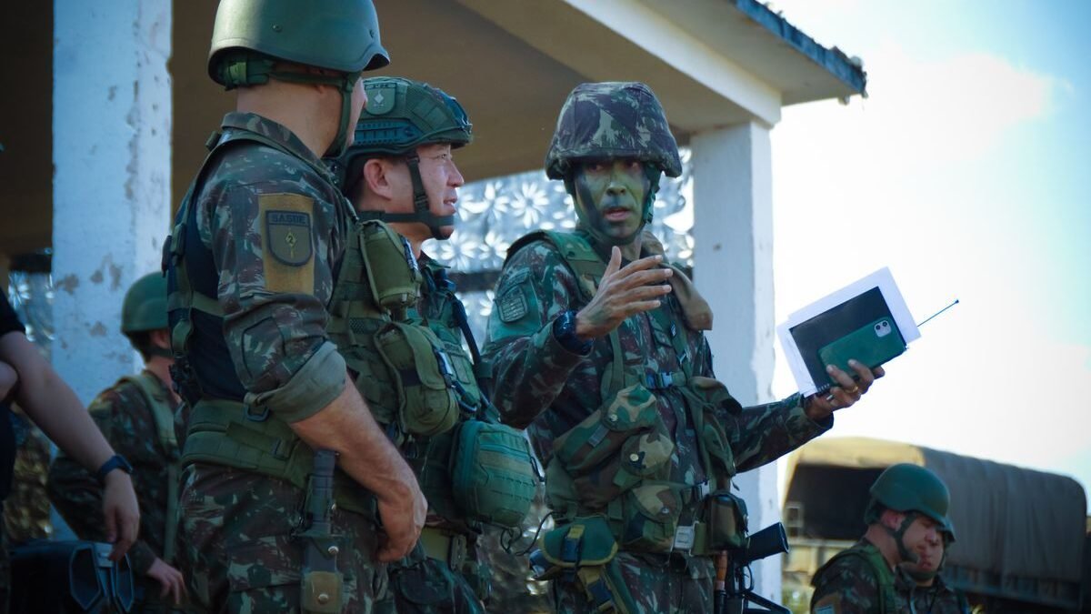 Group of soldiers in camouflage attending a briefing outdoors with tactical gear and helmets
