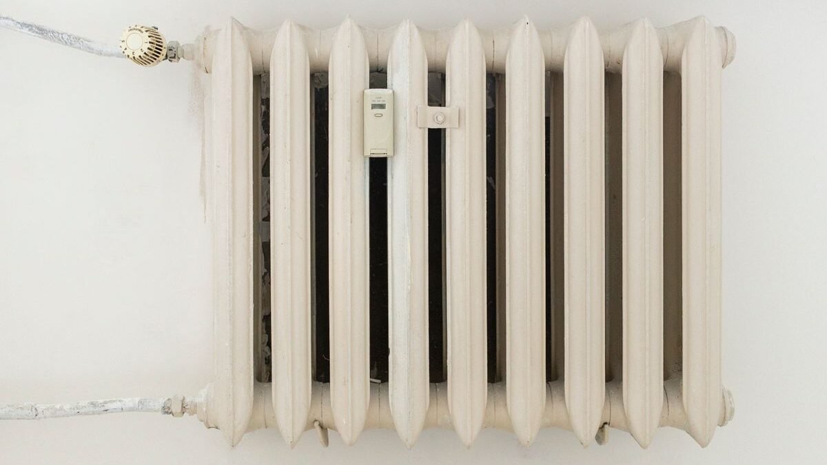 A classic white metal radiator on a plain wall