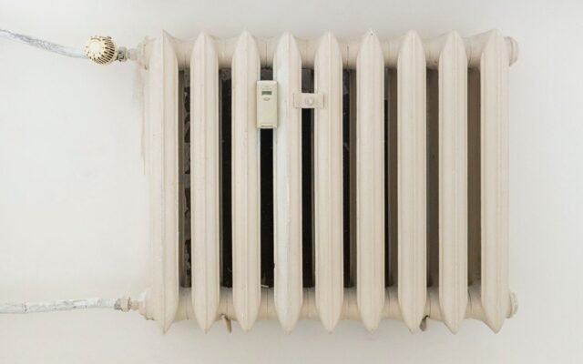 A classic white metal radiator on a plain wall