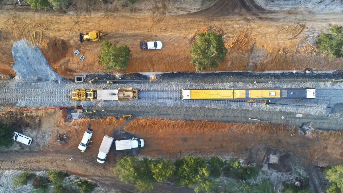 Aerial view of a construction site with machinery and railway tracks