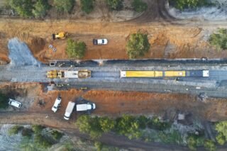 Aerial view of a construction site with machinery and railway tracks