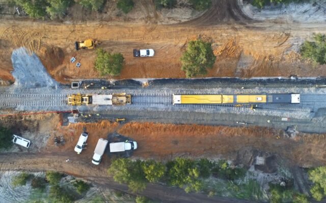Aerial view of a construction site with machinery and railway tracks