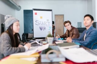 A group of young professionals brainstorming ideas in a startup office setting