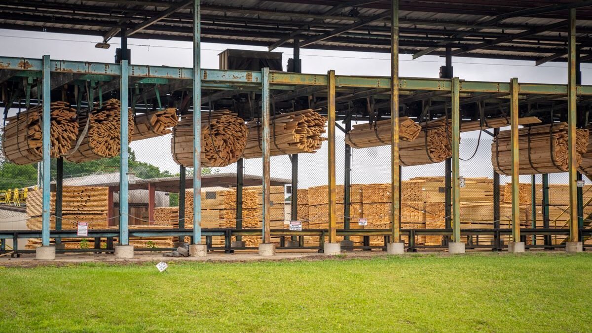 Image of stacked wooden planks in an outdoor lumber yard