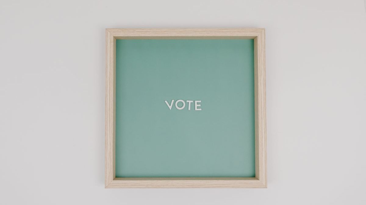 Minimalist wooden frame with 'Vote' text on green backdrop